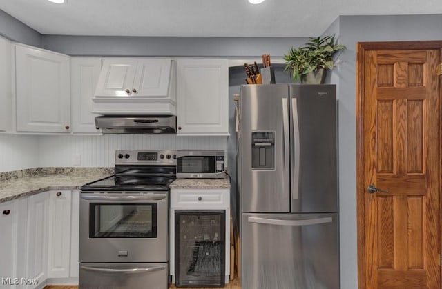 kitchen featuring light stone countertops, appliances with stainless steel finishes, and white cabinets