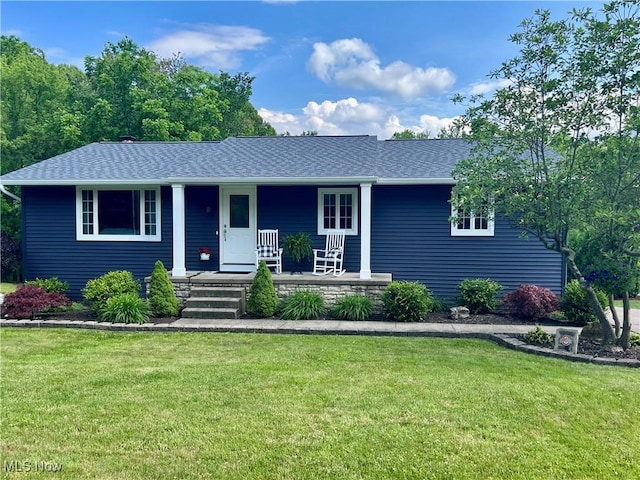 ranch-style house featuring covered porch and a front yard