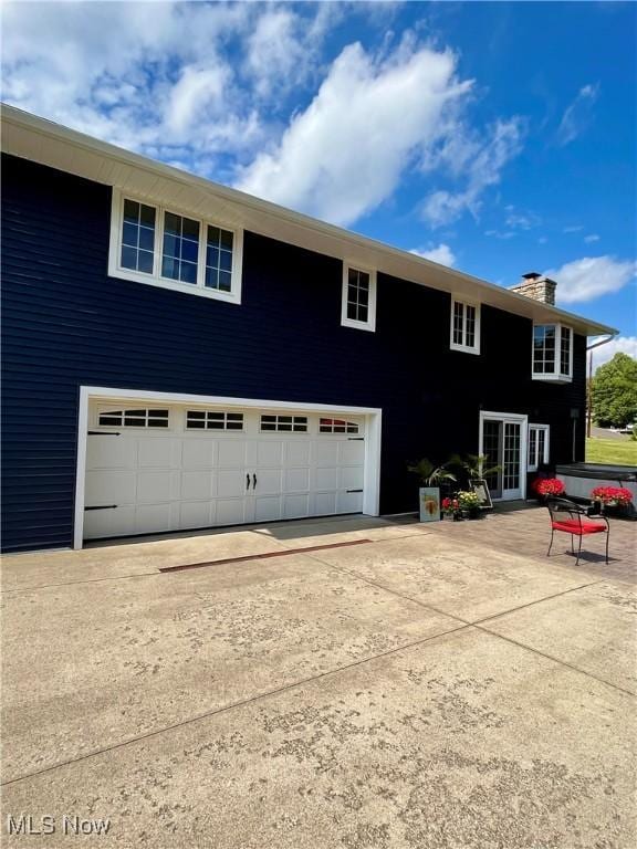 view of property exterior with a garage and french doors