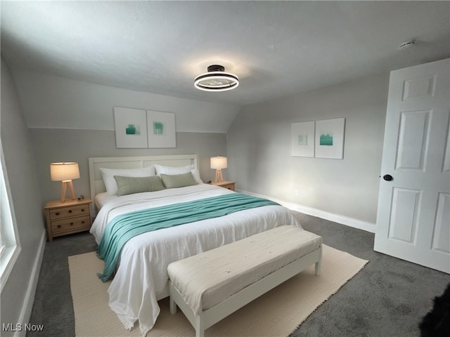 bedroom featuring lofted ceiling and dark carpet