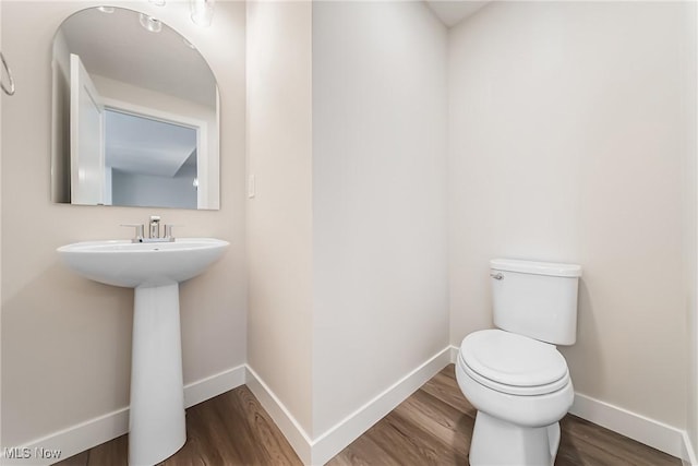 bathroom featuring hardwood / wood-style floors and toilet