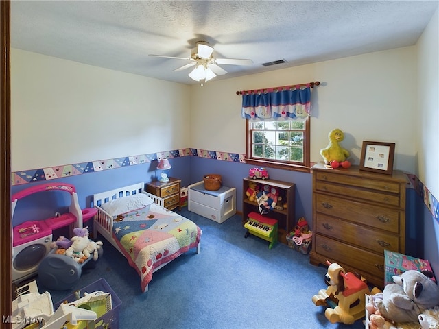 carpeted bedroom featuring ceiling fan and a textured ceiling