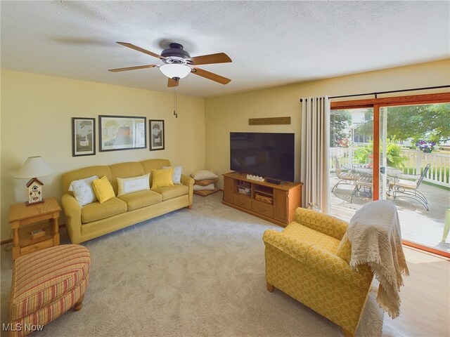 carpeted living room featuring a textured ceiling and ceiling fan