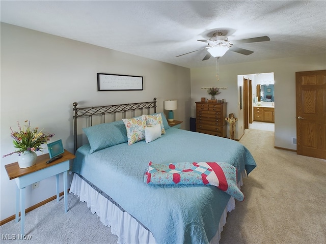 carpeted bedroom with ensuite bath, a textured ceiling, and ceiling fan