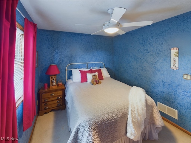 bedroom with ceiling fan and multiple windows