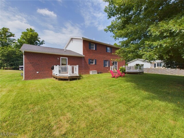 back of house featuring a deck and a yard