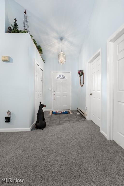 foyer with a notable chandelier and dark colored carpet