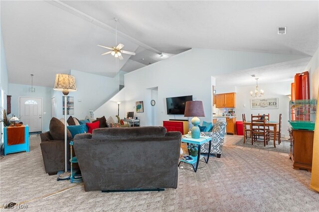 living room with ceiling fan with notable chandelier, vaulted ceiling with beams, and light colored carpet