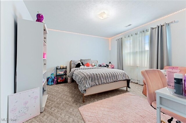 bedroom with lofted ceiling, light colored carpet, and a textured ceiling