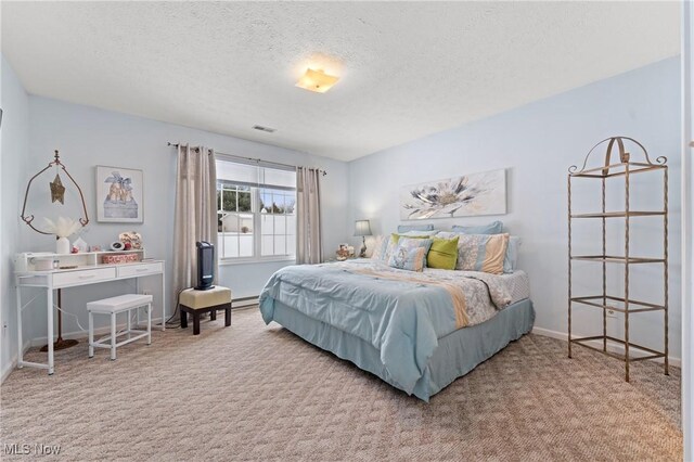 carpeted bedroom featuring a baseboard heating unit and a textured ceiling