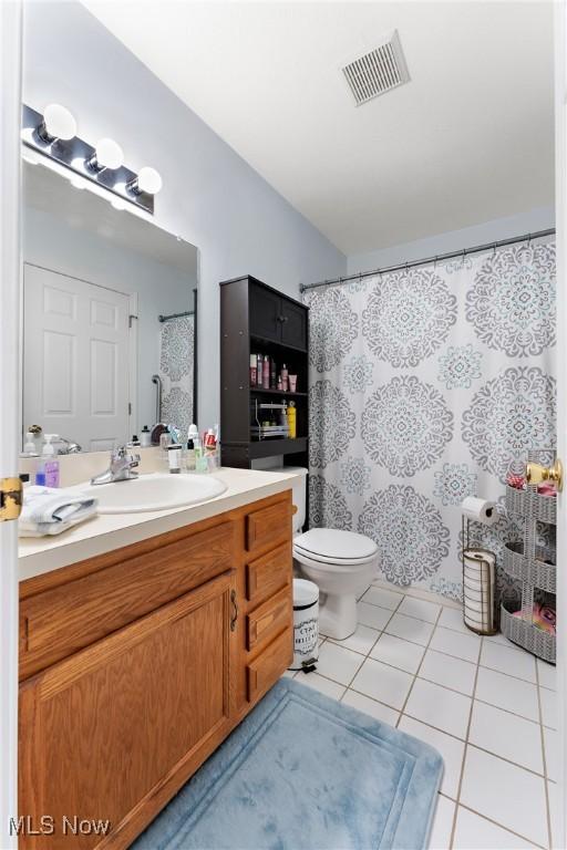 bathroom featuring toilet, vanity, and tile patterned floors