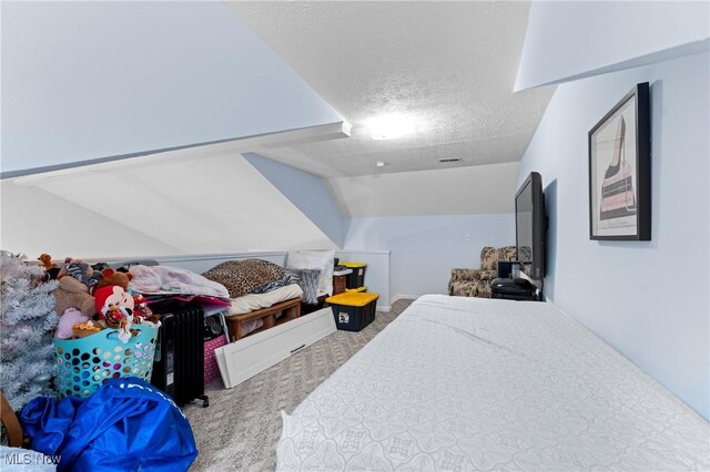 carpeted bedroom with a textured ceiling and vaulted ceiling