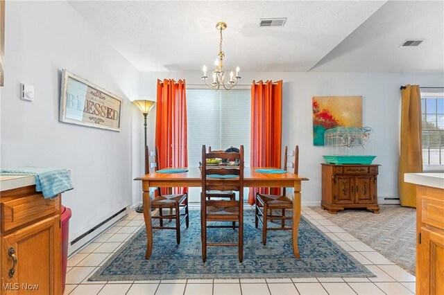 dining room featuring a baseboard heating unit, a textured ceiling, and light tile patterned floors