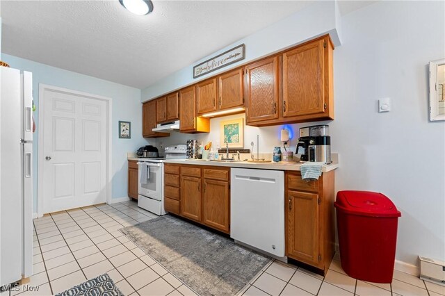 kitchen featuring sink, white appliances, and light tile patterned floors