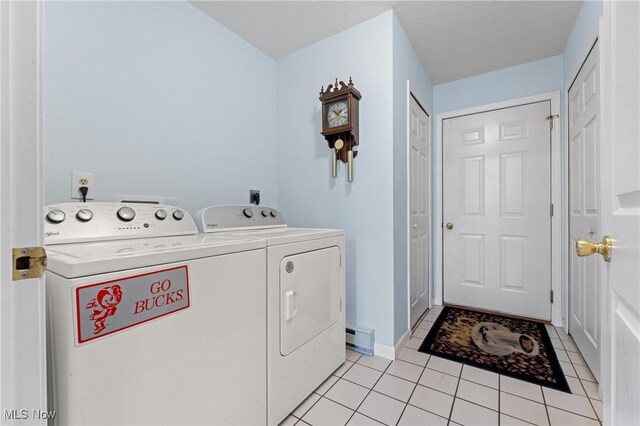 laundry room featuring washer and dryer, baseboard heating, and light tile patterned floors