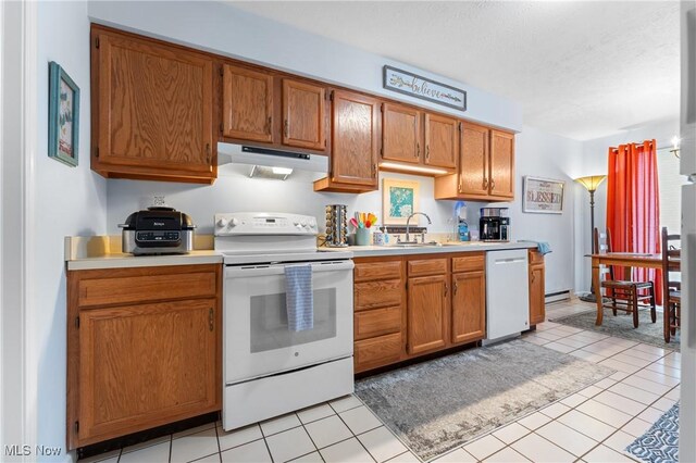 kitchen with sink, white appliances, and light tile patterned floors