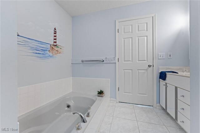 bathroom with vanity, tile patterned flooring, and a relaxing tiled tub