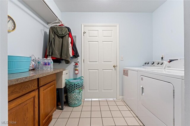 washroom featuring washer and clothes dryer and light tile patterned floors