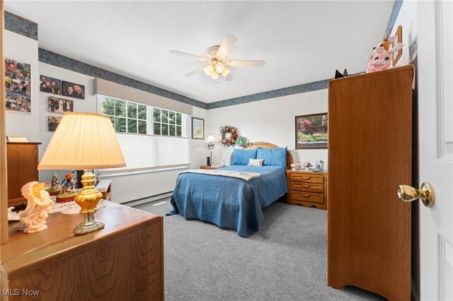 carpeted bedroom with ceiling fan and a baseboard radiator