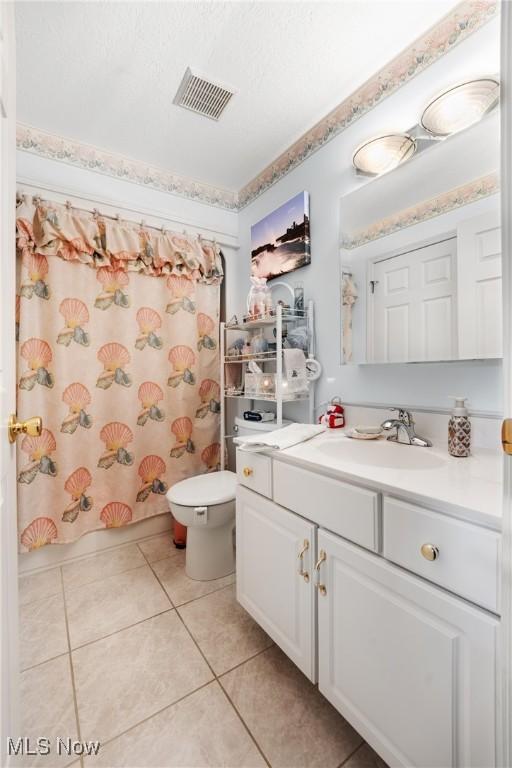 full bathroom with toilet, tile patterned floors, shower / tub combo with curtain, and vanity