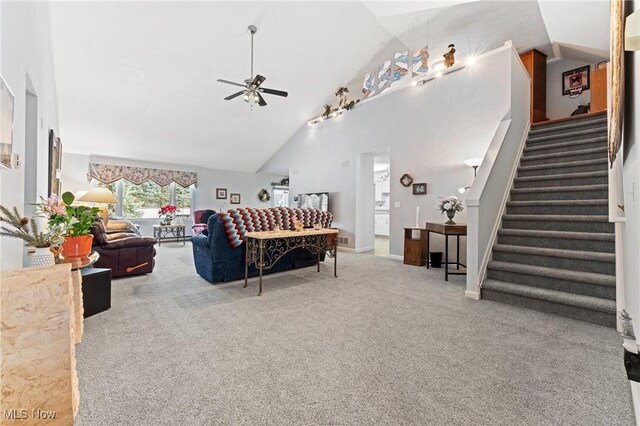 carpeted living room featuring high vaulted ceiling and ceiling fan