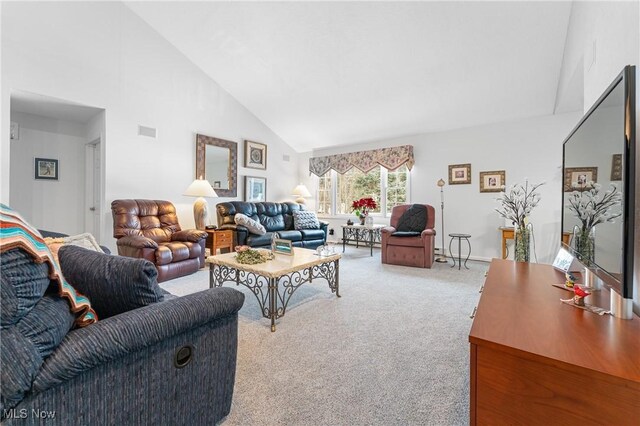 carpeted living room with high vaulted ceiling