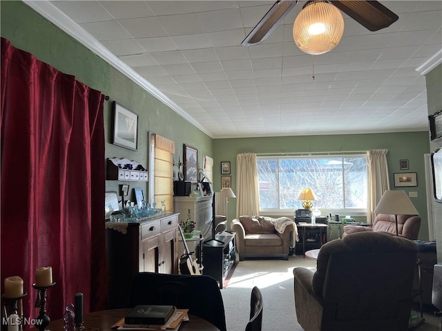 carpeted living room with ceiling fan and ornamental molding