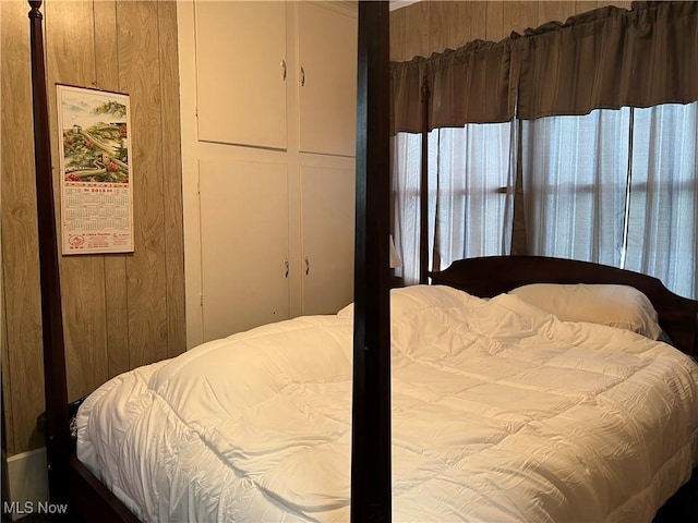 bedroom featuring wooden walls