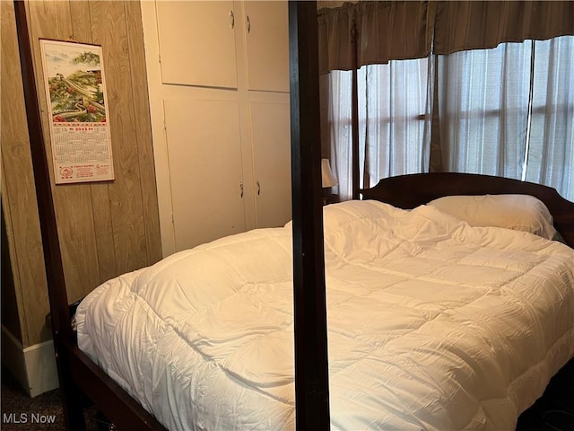 bedroom featuring wood walls