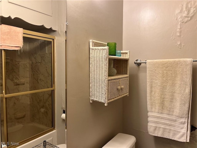 bathroom with a shower with shower door and toilet