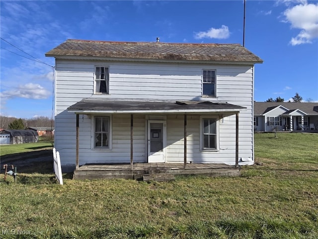 back of house with a porch and a lawn