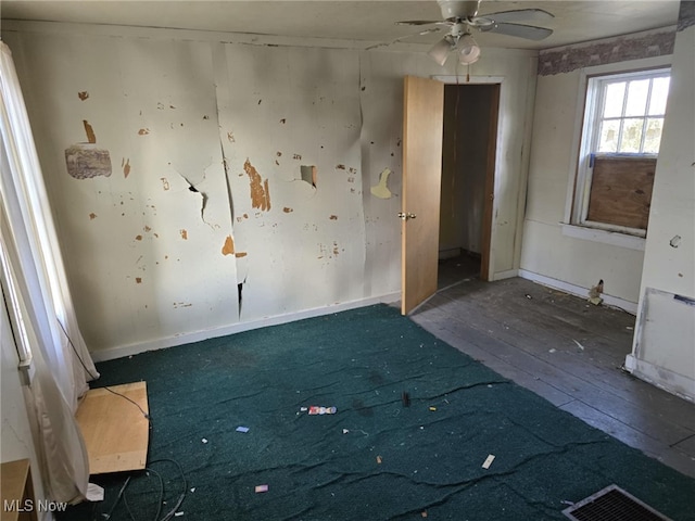 unfurnished room with ceiling fan and dark wood-type flooring