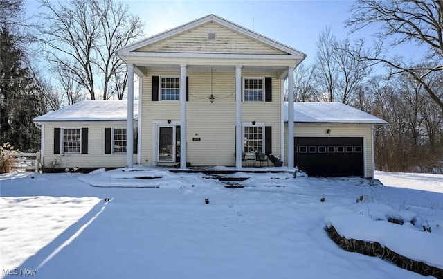 greek revival inspired property featuring a garage