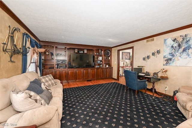 living room with a textured ceiling, crown molding, light hardwood / wood-style floors, and built in shelves