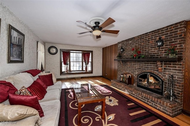 living room featuring ceiling fan, a fireplace, and hardwood / wood-style flooring