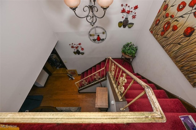 stairway featuring a chandelier