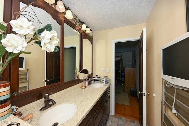 bathroom with a textured ceiling and vanity