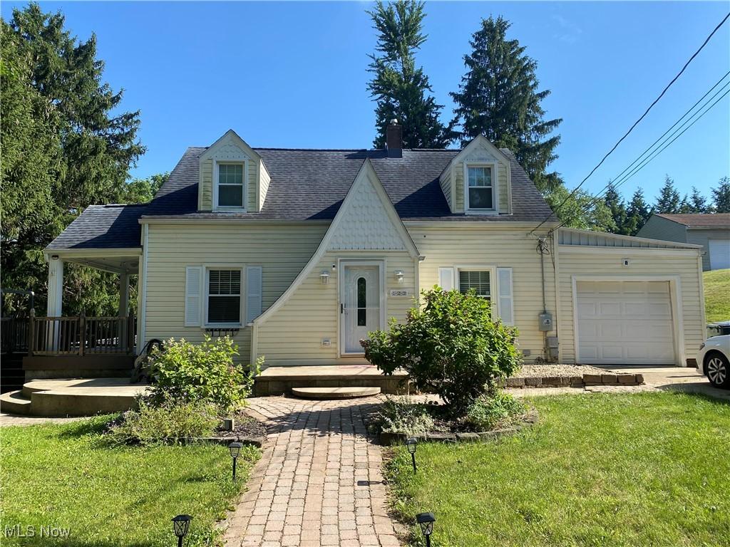 new england style home featuring a front yard and a garage