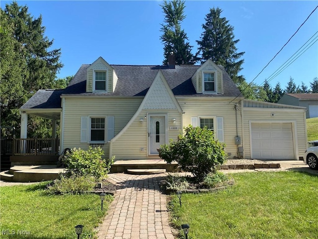 new england style home featuring a front yard and a garage