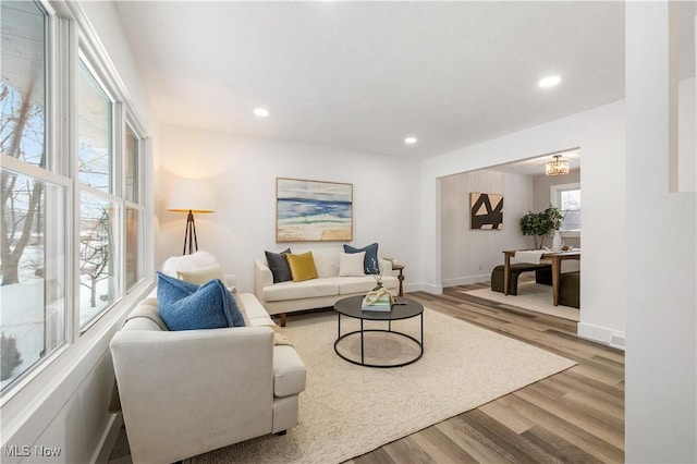 living room with light hardwood / wood-style flooring and an inviting chandelier