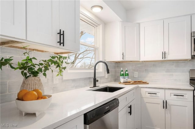 kitchen featuring white cabinetry, dishwasher, tasteful backsplash, and sink