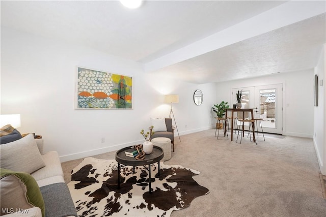 sitting room featuring french doors and light carpet