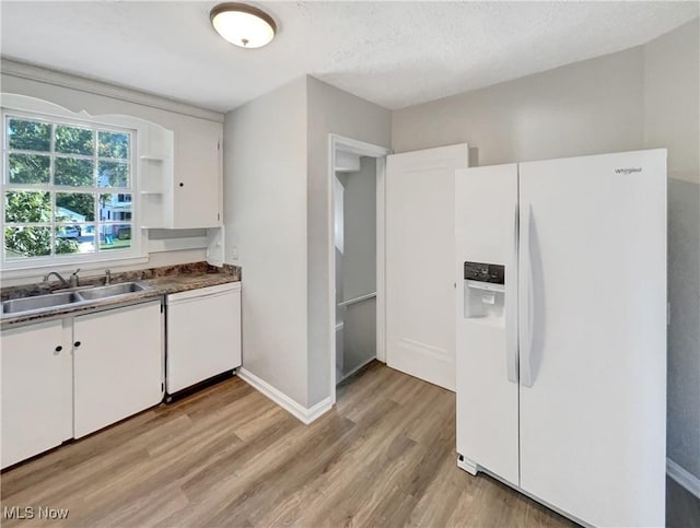 kitchen featuring sink, white appliances, white cabinetry, and light wood-type flooring