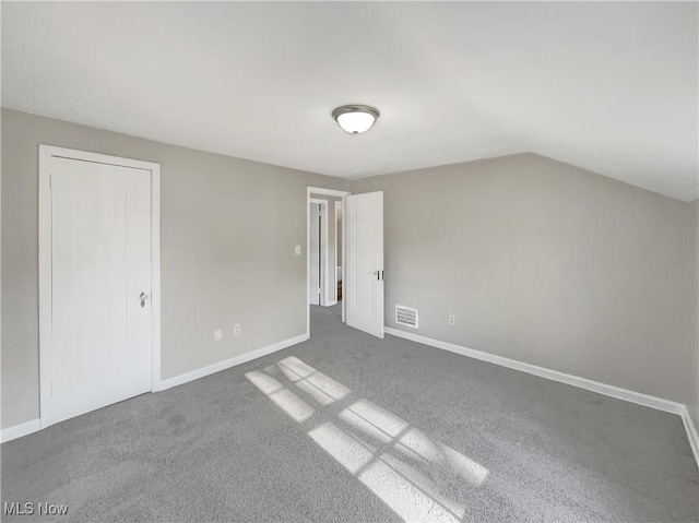 additional living space with lofted ceiling and dark colored carpet