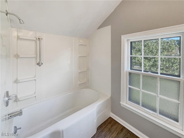 bathroom with vaulted ceiling, shower / bathtub combination, and hardwood / wood-style floors