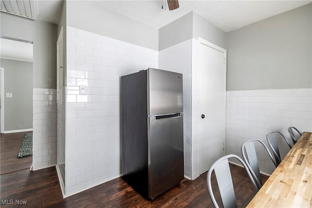 kitchen with tile walls, wooden counters, dark hardwood / wood-style floors, and stainless steel refrigerator