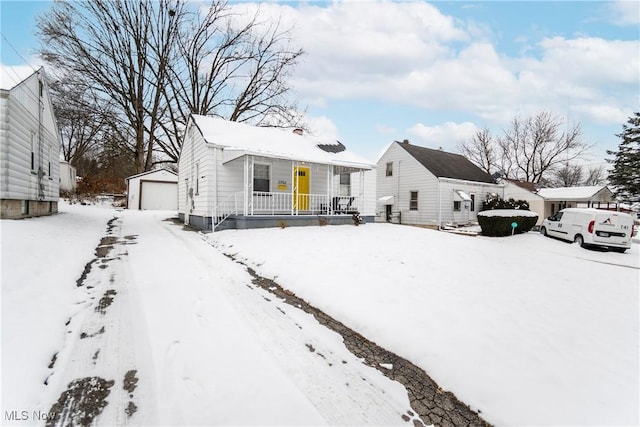 view of front of property with covered porch, a garage, and an outdoor structure