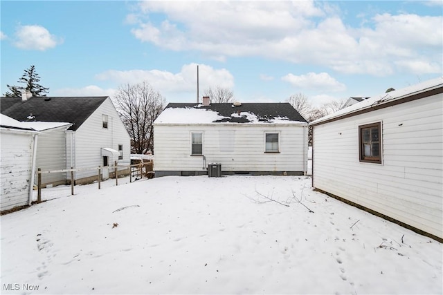 snow covered house featuring cooling unit