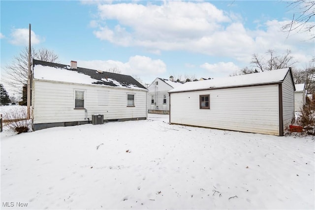 snow covered property with central AC unit