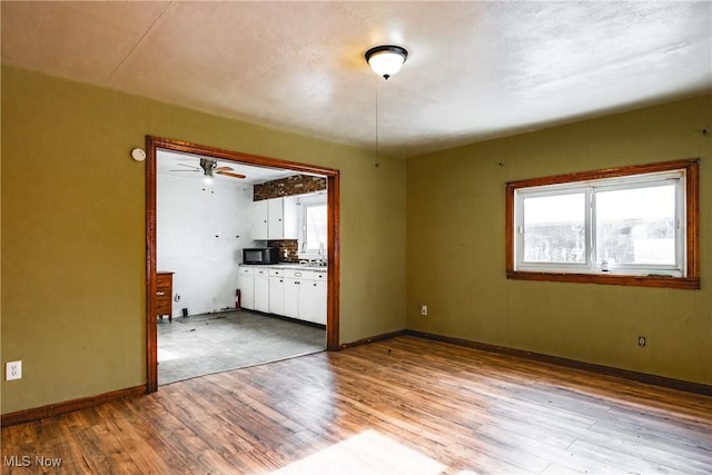 interior space featuring light wood-type flooring, ceiling fan, and sink